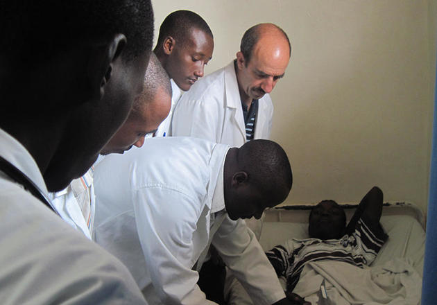 Dr. Andre Sofair, a professor of medicine at Yale, observing a Rwandan resident examining a patient.